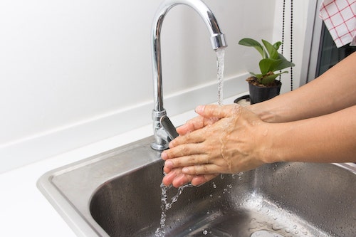 Hände waschen am Edelstahlspülbecken